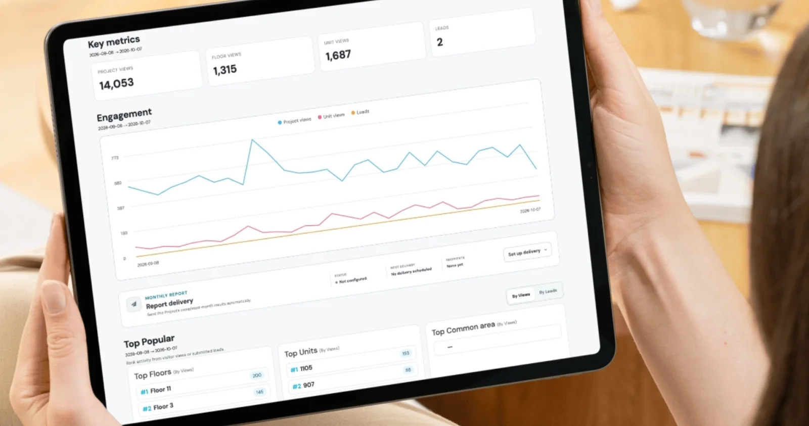 Une personne consulte le tableau de bord d’analyse Smart Condo Plans sur une tablette